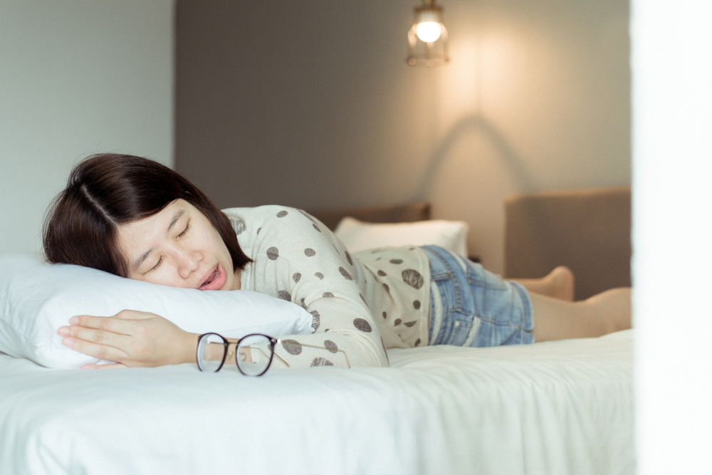 tired asian woman lying on bed