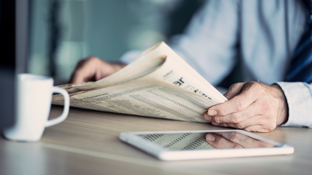 Businessman reading the newspaper on table