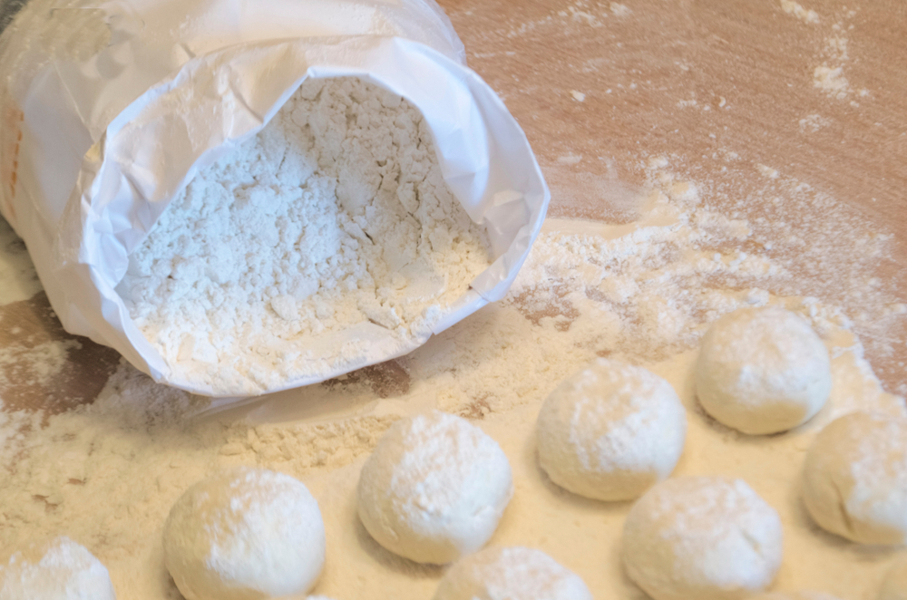wheat flour in a white package and soft dough for baking, cheesecakes and bread. knead and sculpt the dough. soft focus.