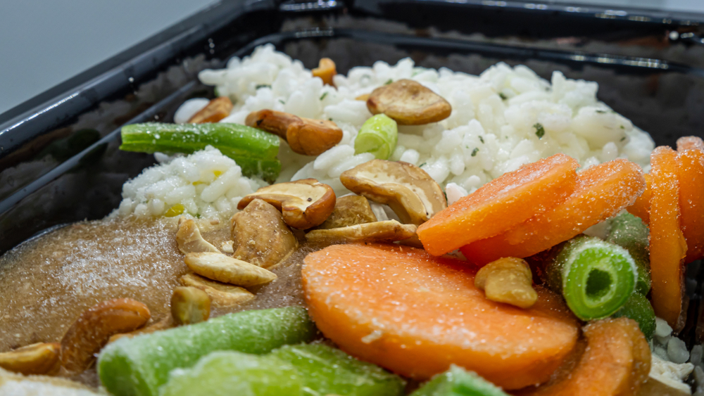 Frozen meal in a microwavable container. Includes chicken, cashews, rice, vegetables as carrots, green beans, peas and others.