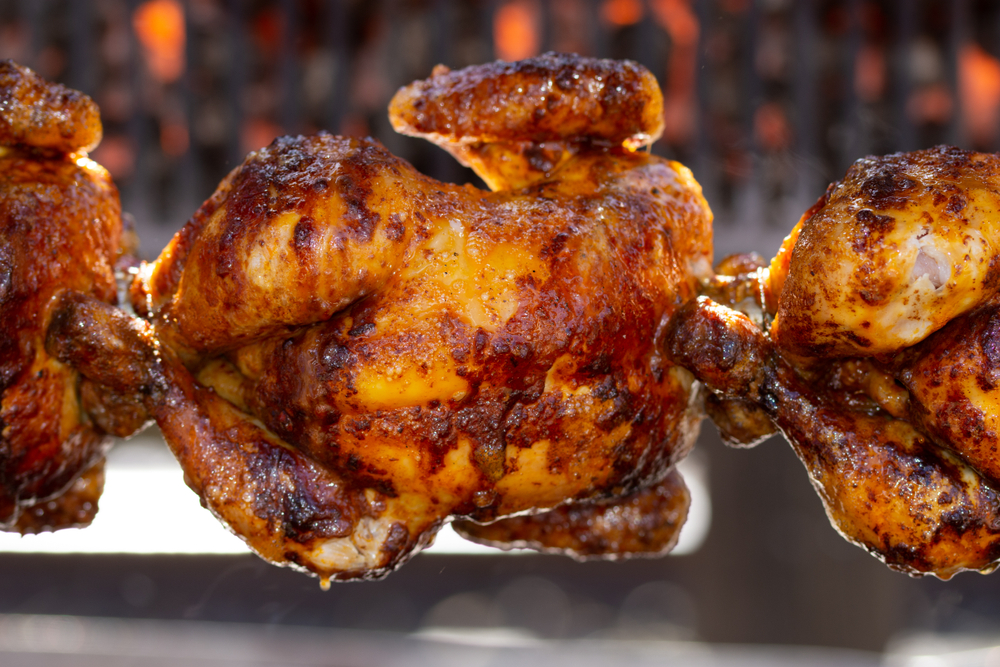 Rotisserie Chicken ,Roasted chickens on spit grilled over fire of a big barbecue,
