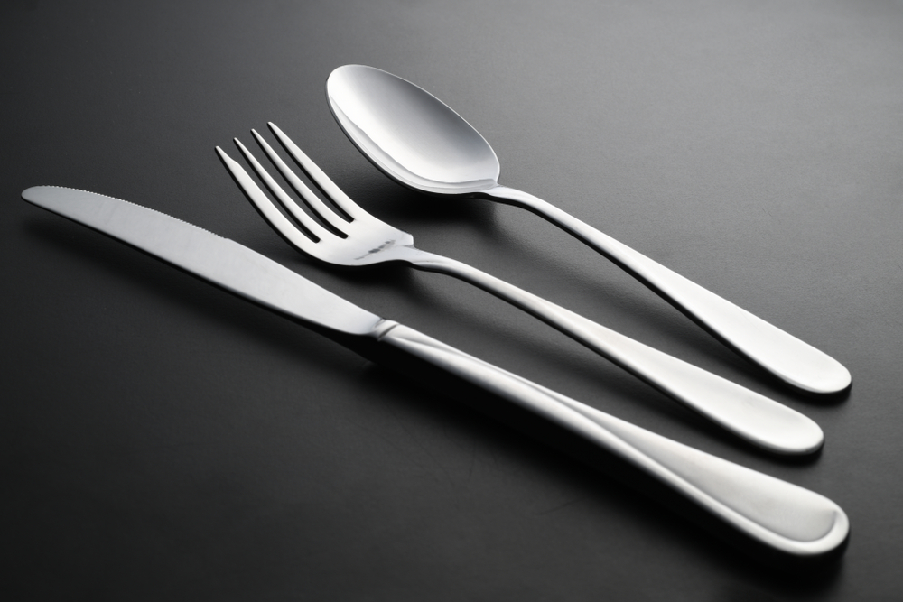 Abstract image of knife, spoon and fork on dark background