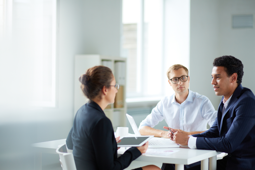 Portrait of smart business partners communicating at meeting

