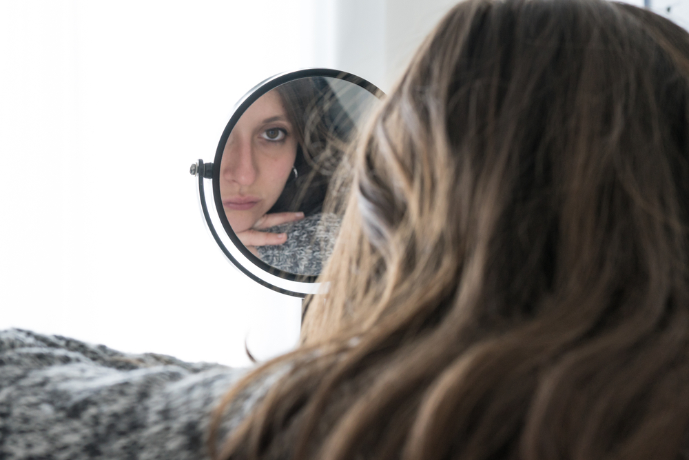 woman looking in mirror