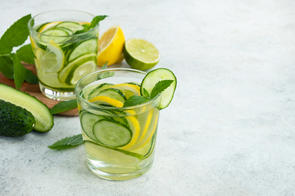 Infused water with cucumber, lime, lemon and mint in glass. Detox, healthy drink.