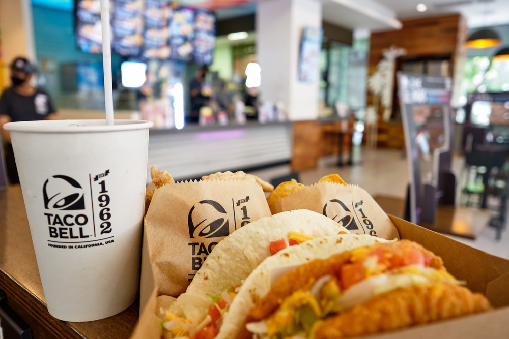 BANGKOK, THAILAND- JULY 24, 2020 : Box set of tasty taco, nachos, and cup of drink served in retail background of taco bell restaurant. A popular Mexican & American fast food chain. Selective focus.