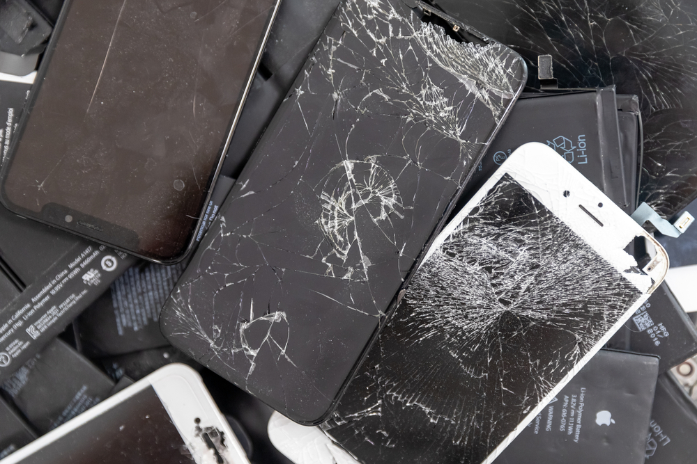 Broken iPhone Apple phone screens and used rechargeable batteries in recycling repair shop, RUSSIA - July 27, 2020.