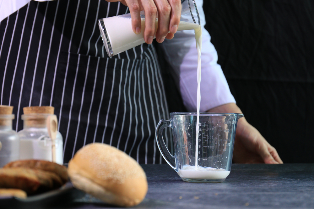 Chef is Pouring Milk into The Measuring Cup
