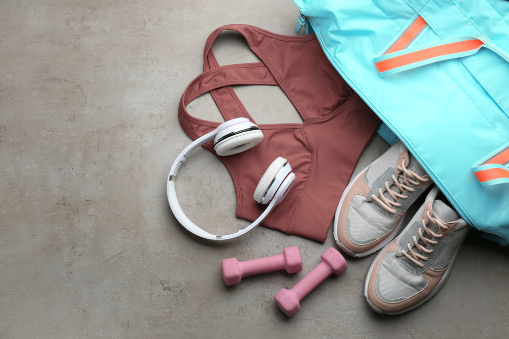 Flat lay composition with gym bag and sportswear on grey table