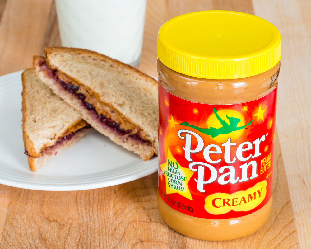 ATLANT - April 28, 2014: Peter Pan brand peanut butter with a peanut butter and jelly sandwich and a glass of milk. 