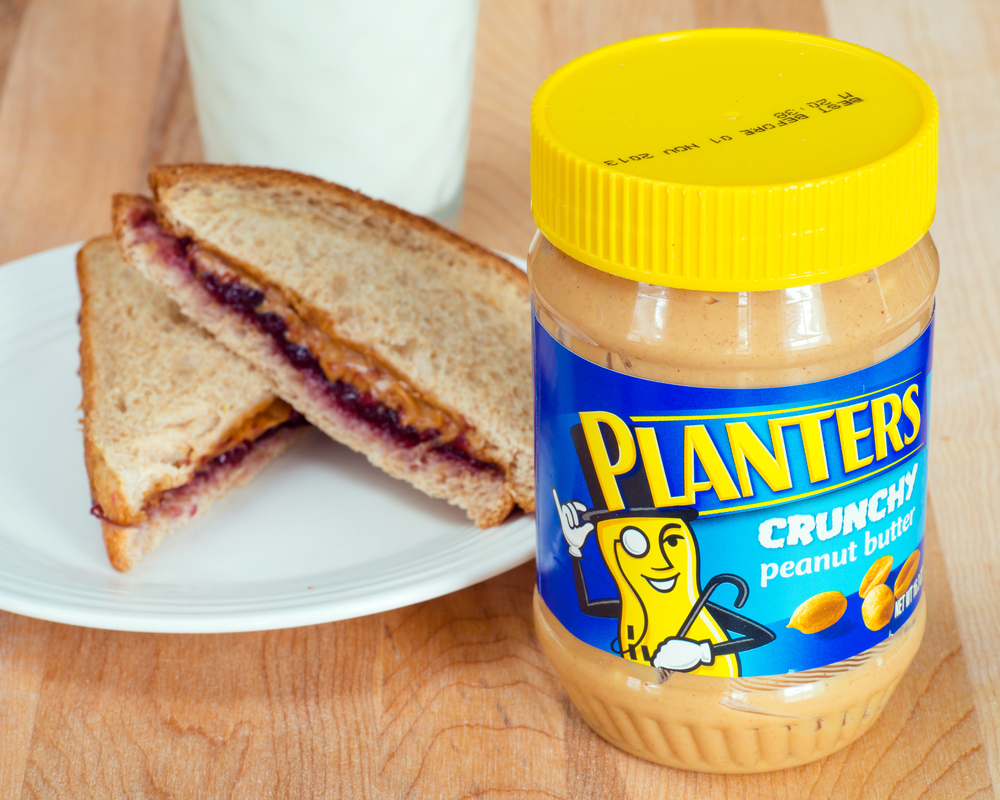 ATLANT - April 28, 2014: Planters brand peanut butter with a peanut butter and jelly sandwich and a glass of milk. 
