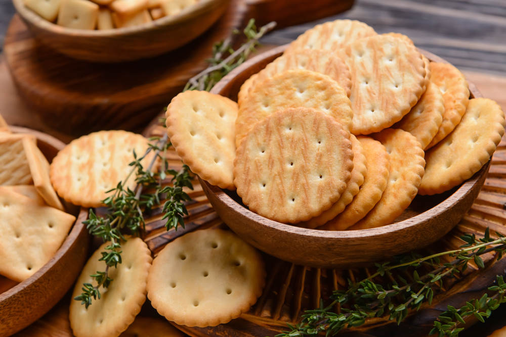 Bowl with crackers on wooden background