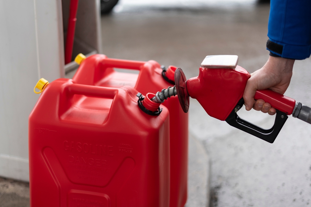 A man fills jerry cans at a gas station, Quebec, Canada.
