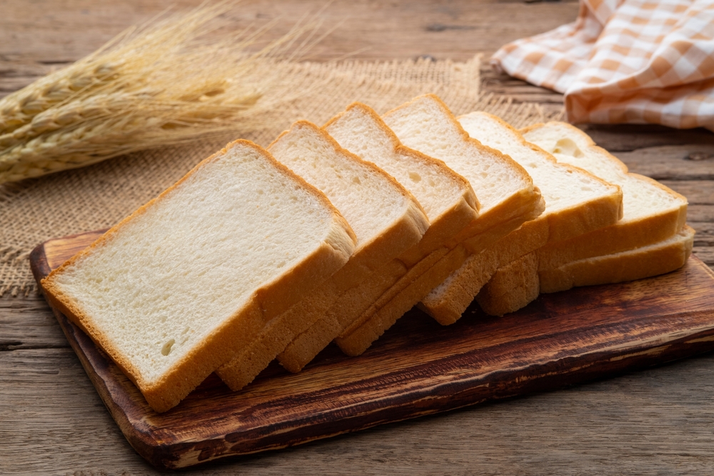 Sliced white bread on wooden board