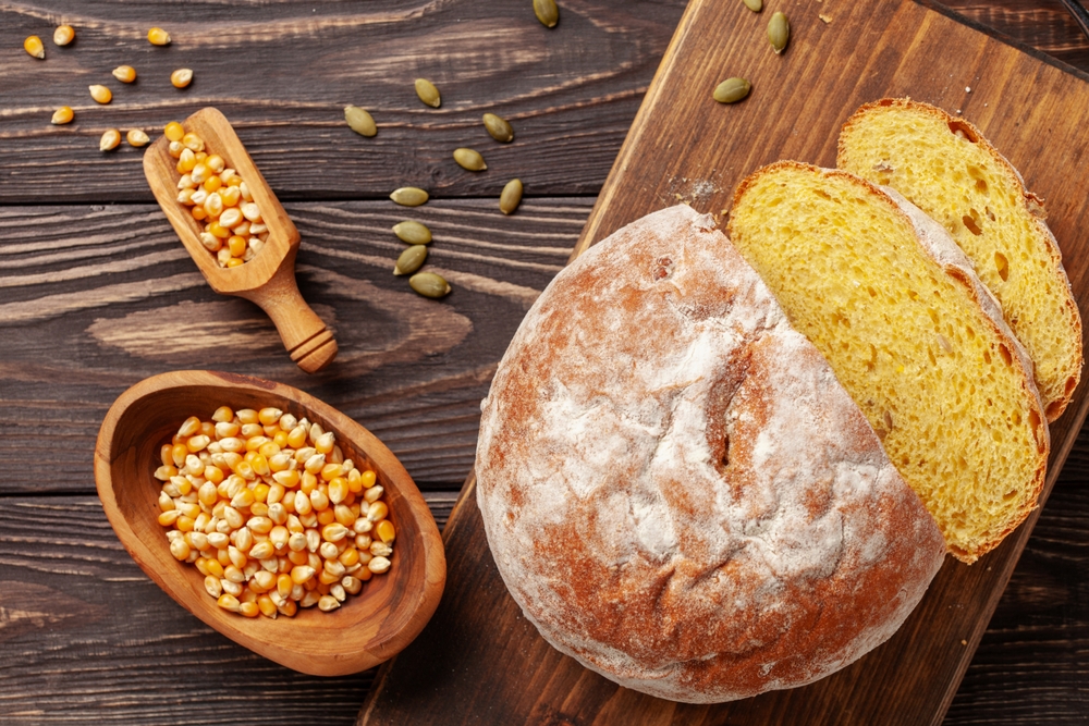 Fresh cornbread and corn grains on the table. Food grain crisis concept. Top view