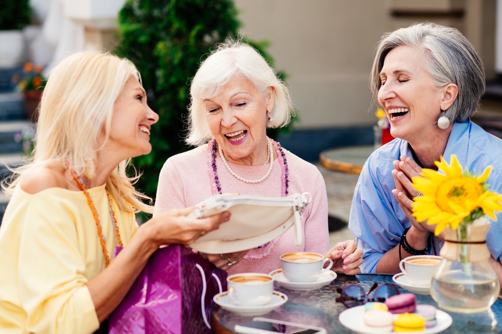 Group of beautiful and happy senior adult women dating outdoors and meeting at the bar cafeteria, having a talk - Stylish fashionable old mature people meeting and having fun in a cafe
