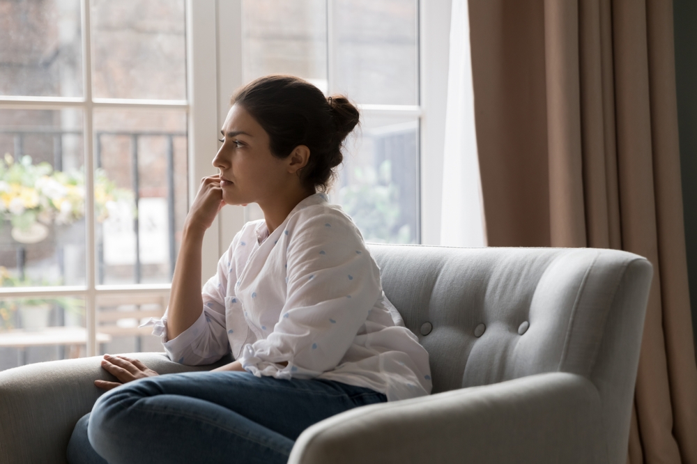woman sitting on couch thinking