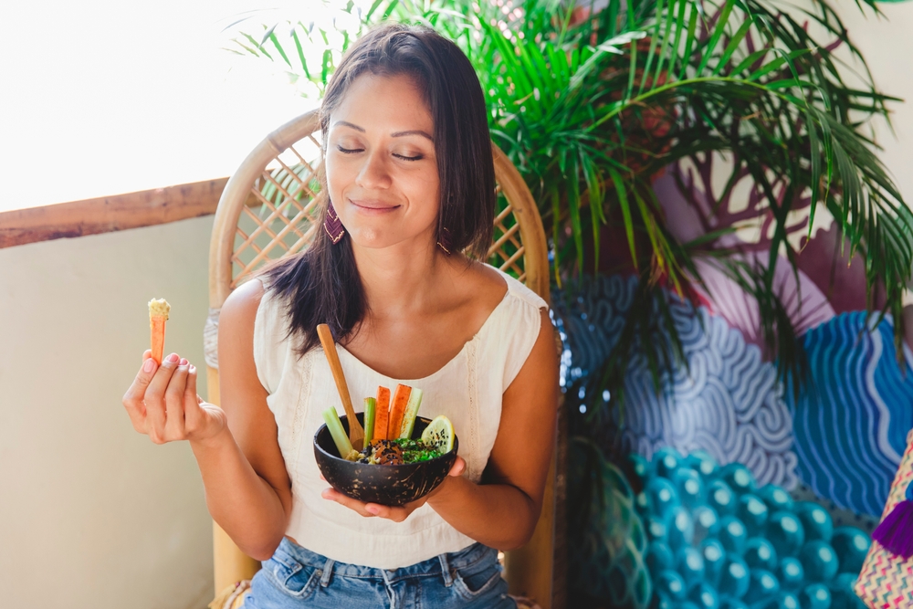 Woman on an organic vegan restaurant, eating a hummus.
