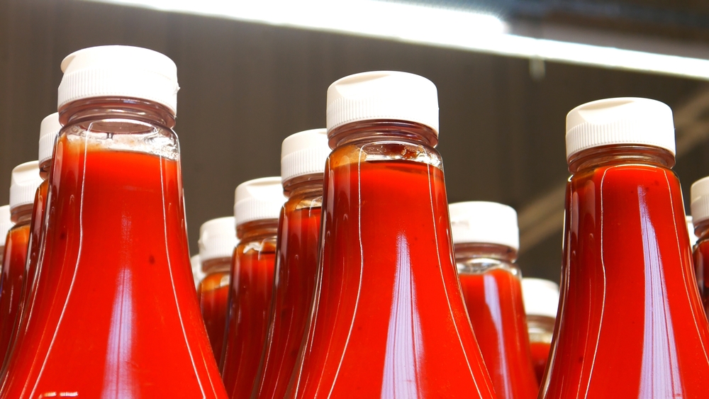 Close-up of many beautiful bottles of ketchup or tomato sauce in a supermarket
