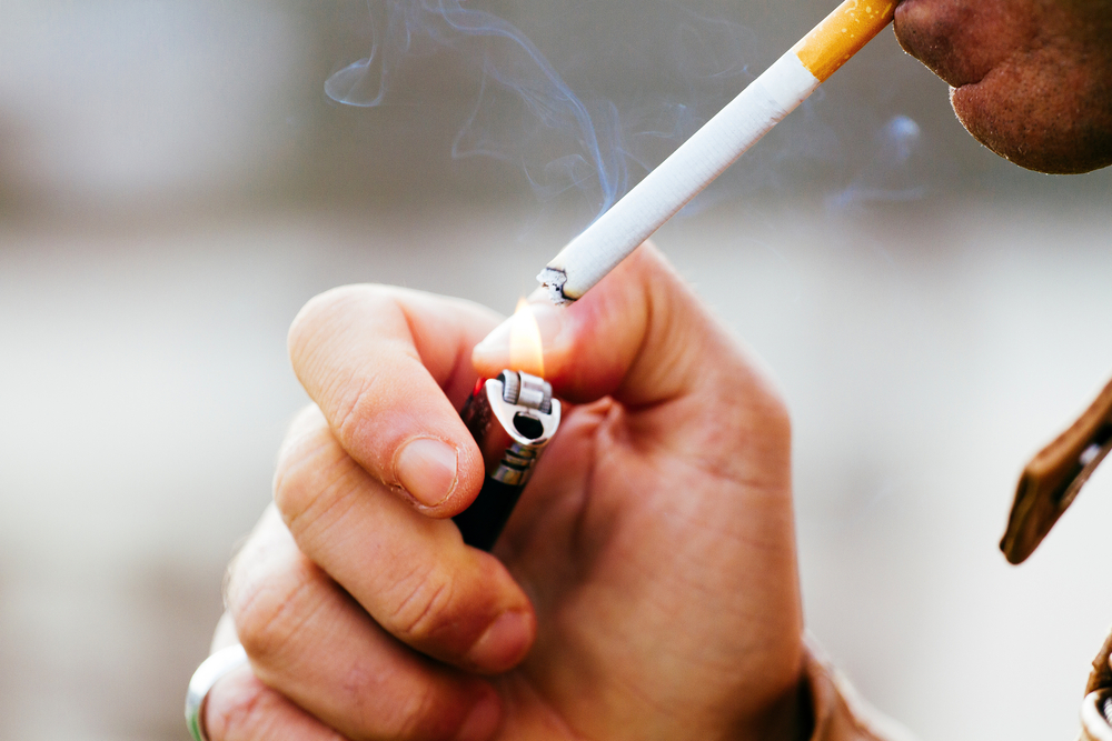 a young man smoking a cigarette
