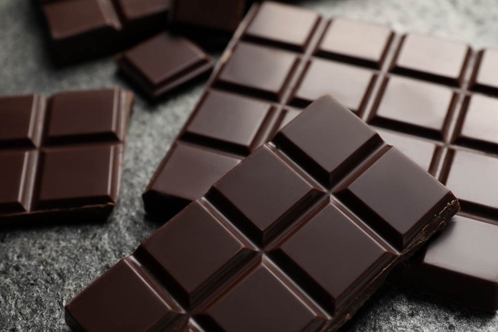 Delicious dark chocolate on grey table, closeup
