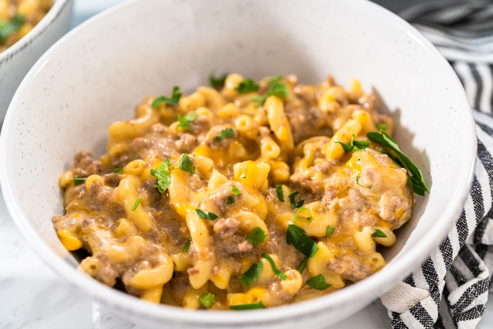 Serving homemade hamburger helper in white ceramic bowls.