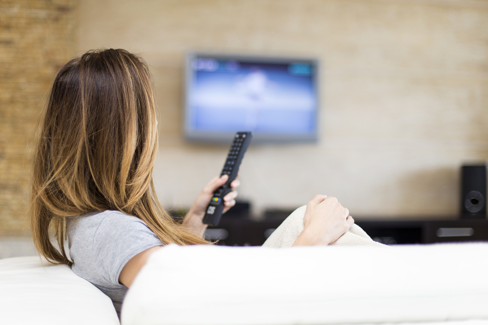 Young woman watching TV in the room
