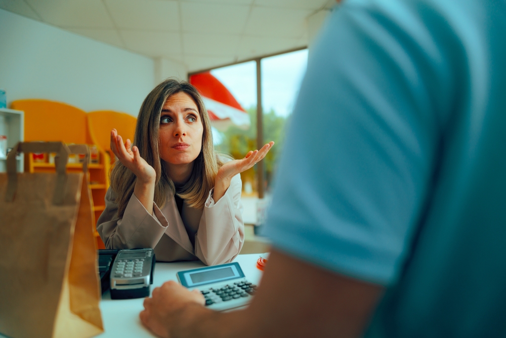 Puzzled Client Feeling in Doubt at the Counter in a Store. Shrugging customer feeling doubtful complaining about service
