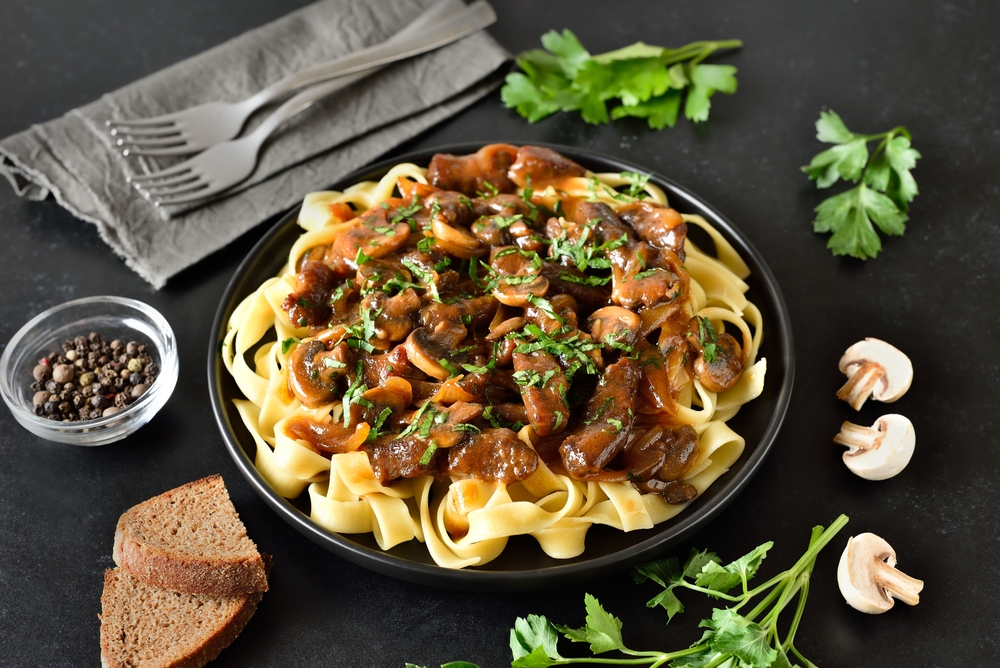 Homemade tasty beef stroganoff with mushrooms and pasta on plate