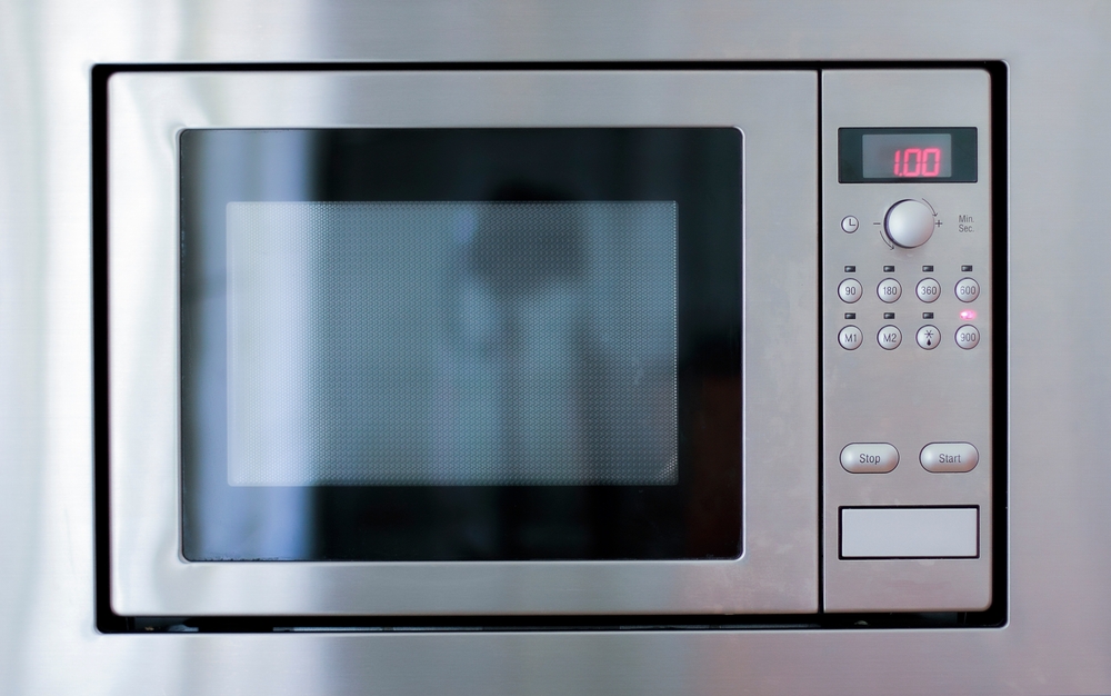Modern Stainless Steel Microwave Oven:This high-quality stock photo captures a sleek, modern microwave oven made of stainless steel. The image highlights the minimalist design and digital control pane