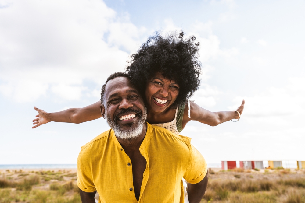 Beautiful mature black couple of lovers dating at the seaside - Married african middle-aged couple bonding and having fun outdoors, concepts about relationship, lifestyle and quality of life
