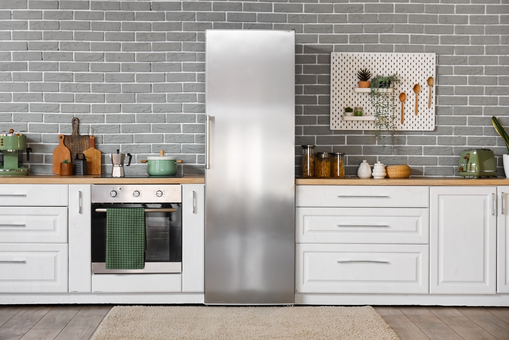 Interior of modern kitchen with counters and stylish fridge