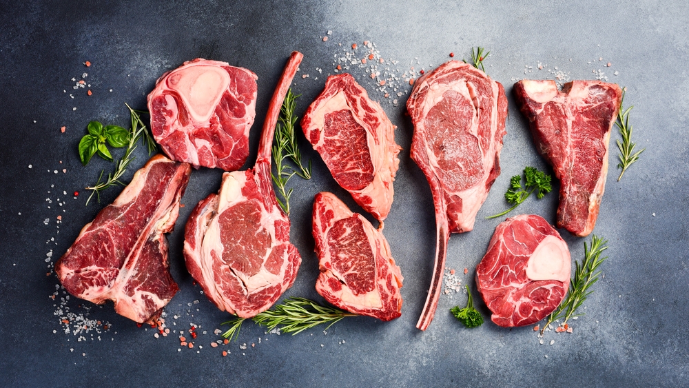 Variety of raw beef meat Prime steaks for grilling with seasoning: Tomahawk steak, Ribeye, T-bone and Ossobuco steak. Meat background.