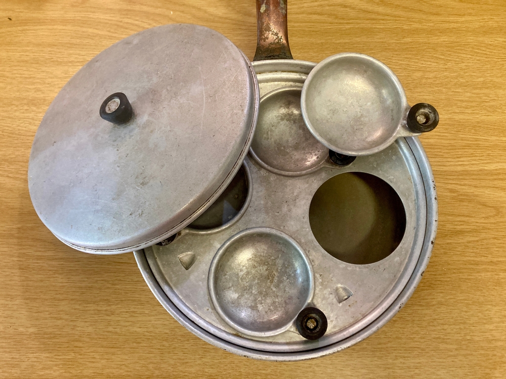 Retro egg poacher isolated on a table in the kitchen