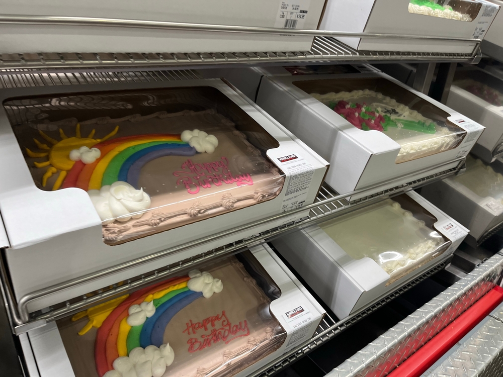 Melbourne, Victoria, Australia – 6 January 2025: Costco bakery shelf with boxed chocolate sheet cakes decorated with rainbows, suns, and birthday messages, perfect for celebrations, parties, and festi