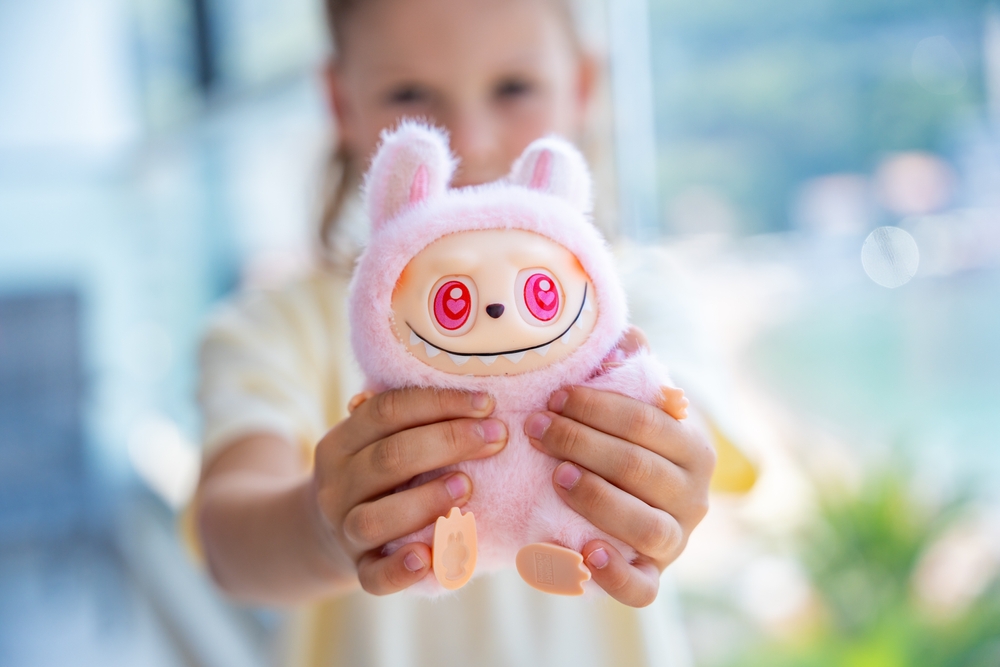 Editorial credit: Tatiana Diuvbanova / Shutterstock.com Budva, Montenegro - June 12, 2025: Close-up of pink Dada figure from Pop Mart LaBubu collection in child hands. Focus on popular collectible toy and emotional connection through play.