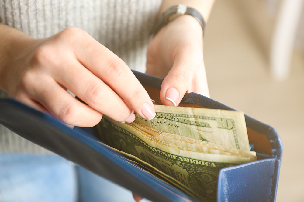 Girl with blue wallet full of money
