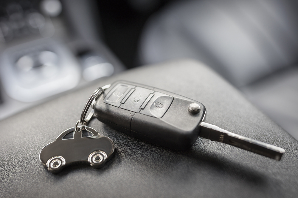 Car shape keyring and remote control key in vehicle interior
