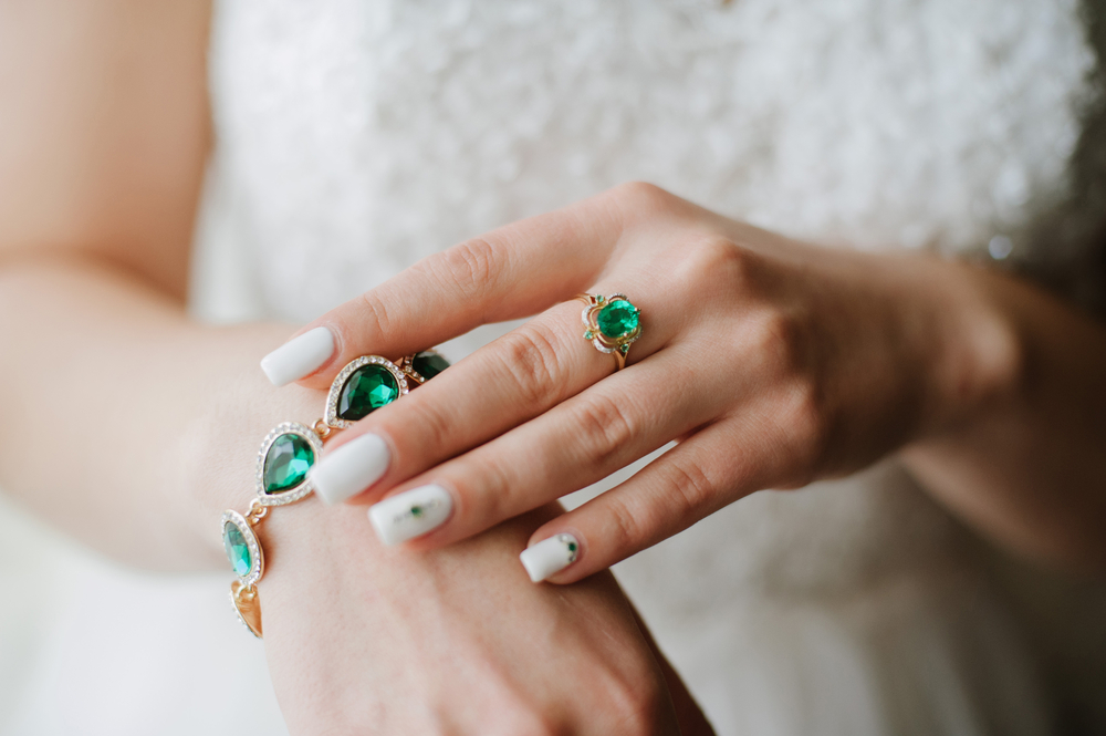 Stylish jewelry with gems of green. On the hands of women beautiful jewelry
