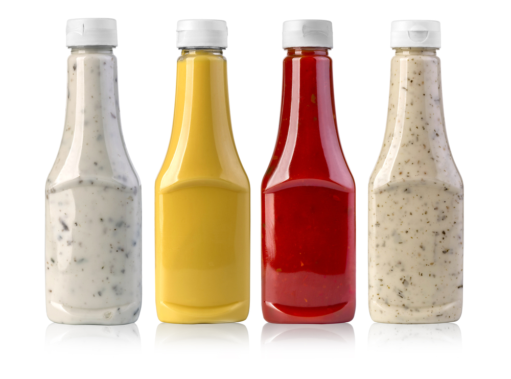 barbecue sauces in glass bottles on white background
