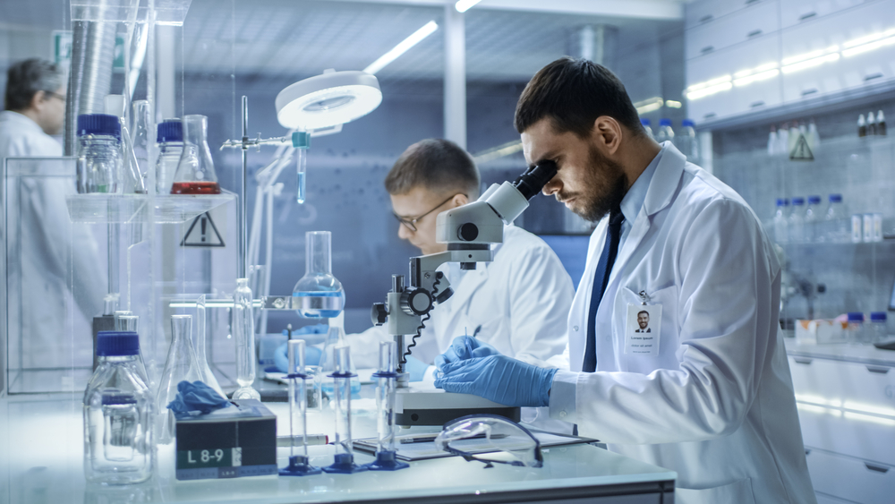 scientists looking through microscope