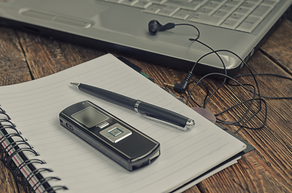 freelancer's work at a computer with a voice recorder