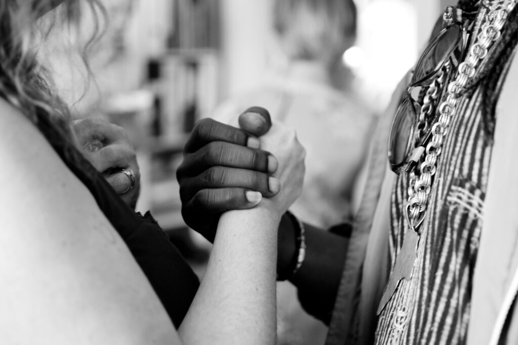 grayscale photo of man and woman holding their hands
