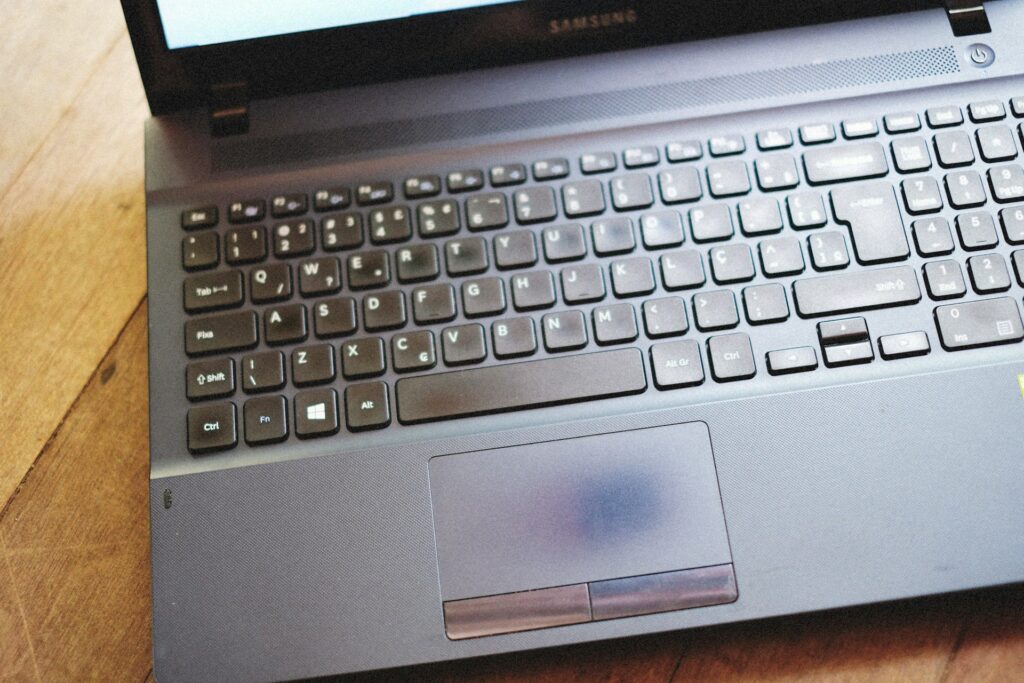 a laptop computer sitting on top of a wooden table

