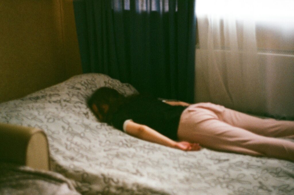 woman in pink shirt lying on bed
