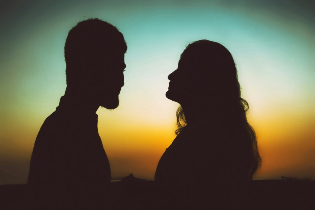 silhouette of man and woman standing during sunset
