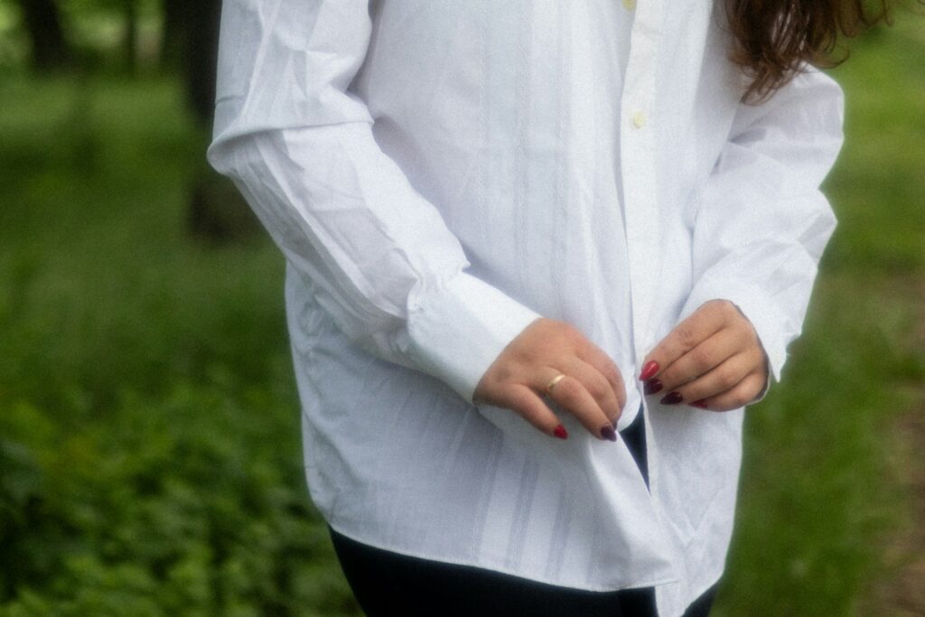 a woman wearing a white shirt and black pants

