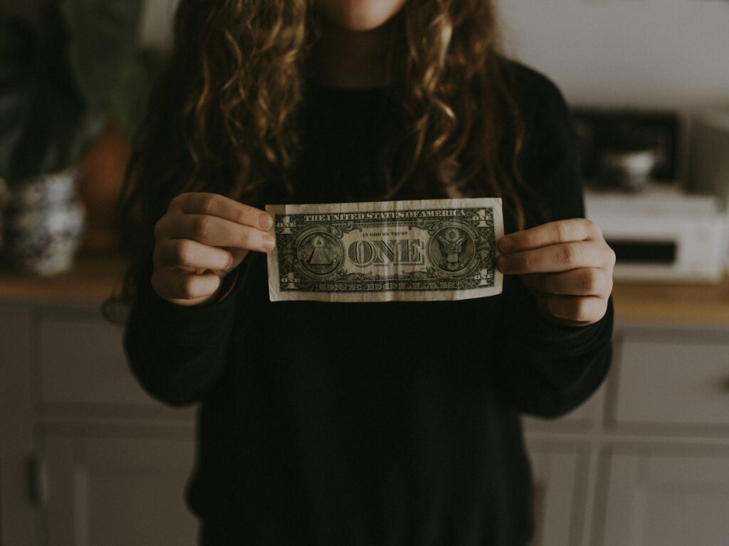 girl holding 1 U.S. dollar banknote
