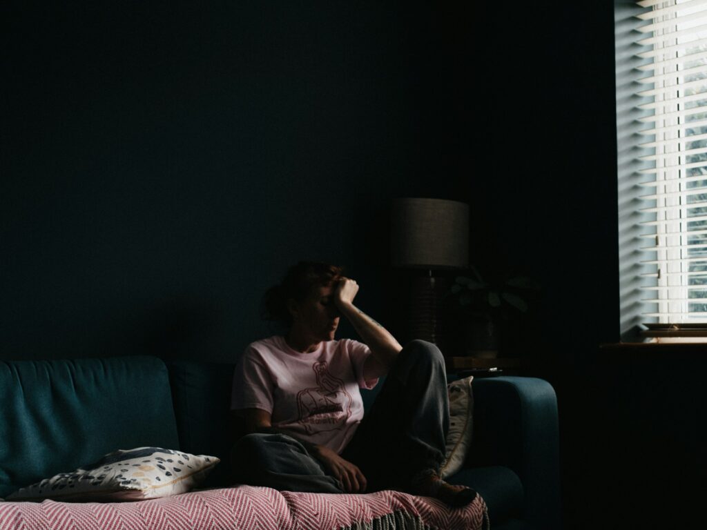 woman in purple dress sitting on couch

