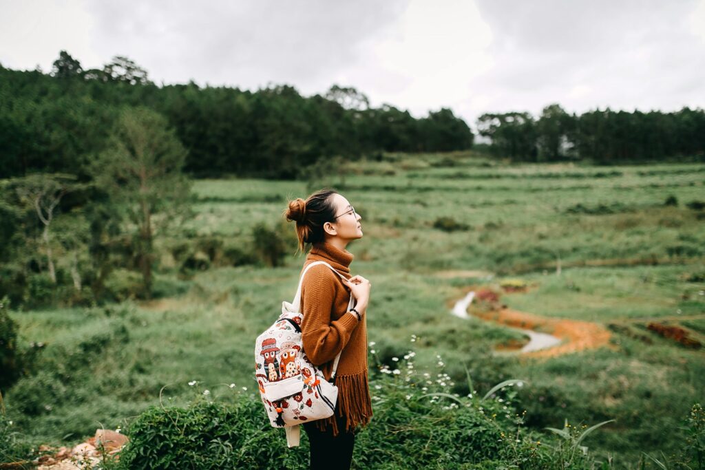 woman standing in the middle of grass field
